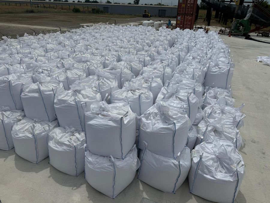 Rows of filled white bulk bags with lifting loops, each bag marked with a number