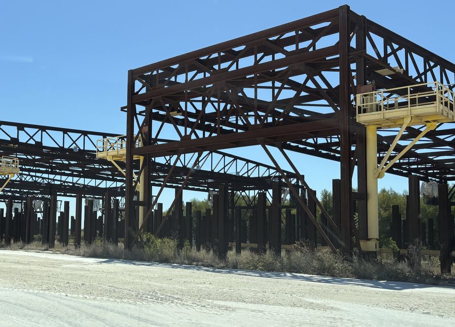 Steel-framed structures with yellow access platforms standing over the yard
